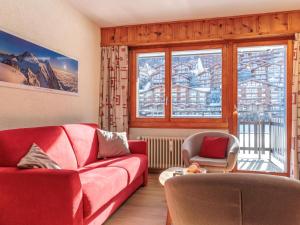 a living room with a red couch and two chairs at Apartment Ecluses 2 by Interhome in Nendaz