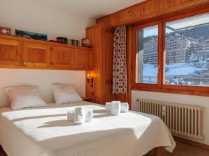 a bedroom with a bed with white sheets and a window at Apartment Ecluses 2 by Interhome in Nendaz