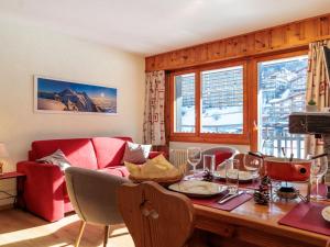a living room with a table and a red couch at Apartment Ecluses 2 by Interhome in Nendaz