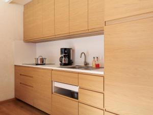 a kitchen with wooden cabinets and a sink at Apartment Ecluses 2 by Interhome in Nendaz