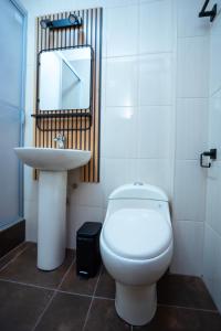 a bathroom with a white toilet and a sink at Samaran Wuasi in Puno +24 photos