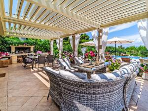 a patio with wicker chairs and tables and a fireplace at Holiday Home Villa Mutnik by Interhome in Mirce