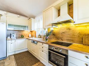 a kitchen with white cabinets and a wooden wall at Holiday Home Villa Mutnik by Interhome in Mirce +37 photos