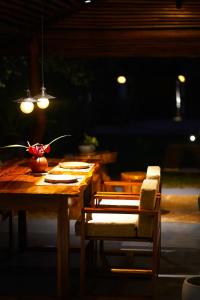 a wooden table and chairs in a room with lights at Zov Wild Yala in Kataragama