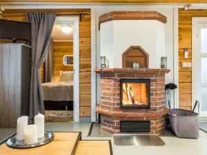 a brick fireplace in a room with a bedroom at Holiday Home Renkitupa by Interhome in Saarenkylä