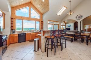 a kitchen with a bar with stools and a table at Rocky Mountain Lodge by Railey Vacations in McHenry