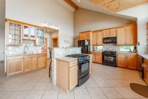 a large kitchen with wooden cabinets and appliances at Rocky Mountain Lodge by Railey Vacations in McHenry +50 photos