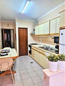 a kitchen with white cabinets and a table in it at LUCINDA`S HOUSE in Braga