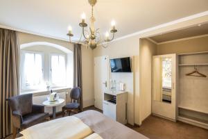 a hotel room with a bed and a table and chair at Schloß-Hotel Petry in Treis-Karden