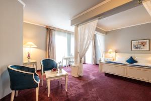 a hotel room with a bed and a table and chairs at Schloß-Hotel Petry in Treis-Karden