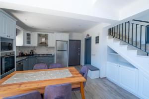 a kitchen with a dining room table and a staircase at Villa Olivin in Fethiye