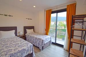 a hotel room with two beds and a balcony at Villa Olivin in Fethiye +5 photos