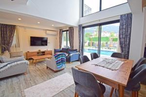 a living room with a table and chairs and a couch at Villa Olivin in Fethiye