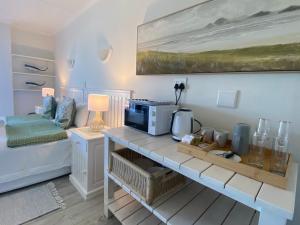 a room with a table with a microwave on it at Sea Paradise in Wilderness