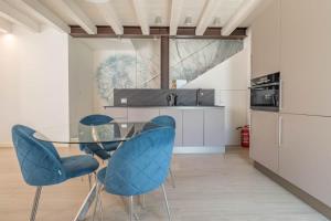 a kitchen with a glass table and blue chairs at Apartment-Boutique Gioia in Cittadella