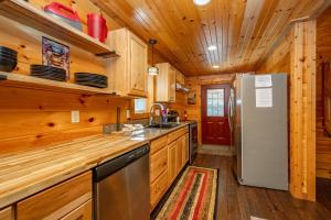 a kitchen with wooden cabinets and a refrigerator at Cozy Cub Cabin by Railey Vacations in McHenry