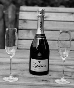 a bottle of wine and two glasses on a table at Owls Nest in Larling