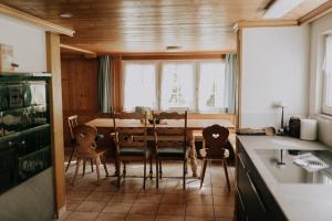 a kitchen and dining room with a table and chairs at 4 bedroom house for 8 guests in Brülisau