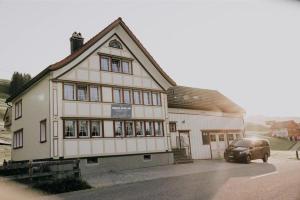 a building with a car parked in front of it at 4 bedroom house for 8 guests in Brülisau