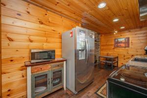 a kitchen with a refrigerator and a microwave at Cozy Cub Cabin by Railey Vacations in McHenry