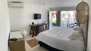 a bedroom with a bed and a desk and a television at Brisas de Centenario in Paso de los Toros