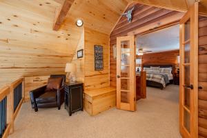 a log cabin bedroom with a bed and a chair at Crows Nest by Railey Vacations in Swanton