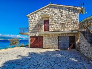 a stone house with a balcony on top of it at Holiday Home Robert by Interhome in Trogir