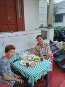 a man and woman sitting at a table with food at IDANN Homestay in Cochin