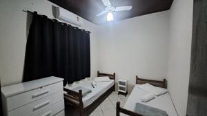 a room with two beds and a ceiling fan at Morada dos Anjos in Aparecida