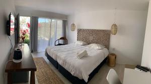a bedroom with a bed and a desk and a window at Brisas de Centenario in Paso de los Toros