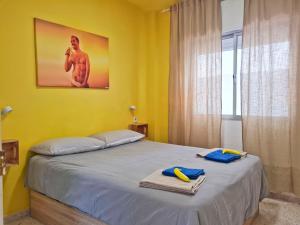 a yellow bedroom with a bed with towels on it at Maracuya House - Men Only in Torremolinos +19 photos