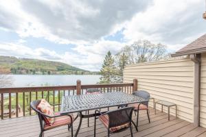 a table and chairs on a deck with a view of a lake at DC Love Shack by Railey Vacations in McHenry