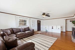 a living room with a couch and a ceiling fan at Lakeside Brick Retreat For 8 in Branson West