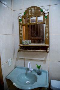 a bathroom with a sink and a mirror at Bosque Love in Juatuba +27 photos