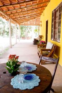 a wooden table with plates and flowers on a patio at Bosque Love in Juatuba