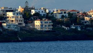a group of houses on a hill next to a body of water at Almyra seaside in Perdika