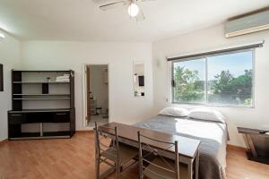a bedroom with a bed and a table and a window at Departamento Palmerín in La Paz