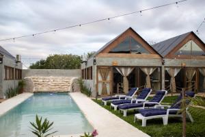 ein Haus mit Swimmingpool und Liegestühlen in der Unterkunft Cabañas Tzikin, Telchac Puerto in Telchac