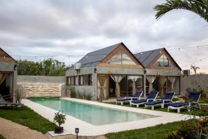 ein Haus mit einem Swimmingpool und Stühlen drumherum in der Unterkunft Cabañas Tzikin, Telchac Puerto in Telchac