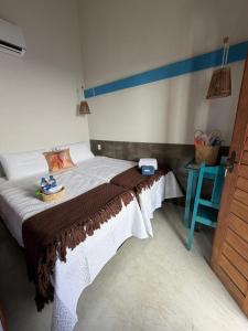 a bedroom with a bed and a blue table at Pousada Villa Santorini Preá in Cruz