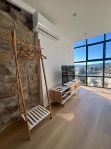 a living room with a stone wall and a tv at Apartamentos-loft A Muralla in Tui