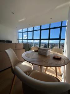 a table and chairs in a room with a large window at Apartamentos-loft A Muralla in Tui