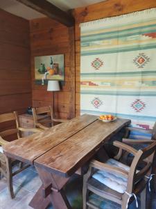 a dining room with a wooden table and chairs at Chata Balówka in Cisna
