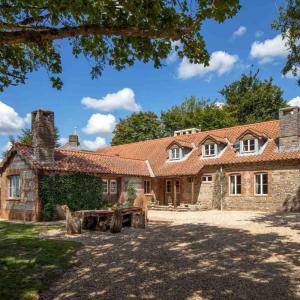 an old stone house with a picnic table in front of it at The Shooting Lodge in Charminster