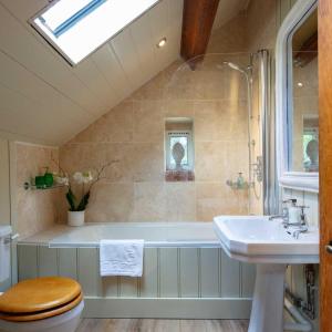 a bathroom with a sink and a toilet and a tub at The Shooting Lodge in Charminster +32 photos