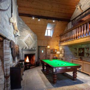 a pool table in a room with a fireplace at The Shooting Lodge in Charminster