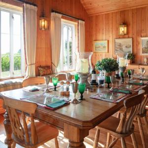 a wooden dining room table with chairs and a large table with vases at The Shooting Lodge in Charminster