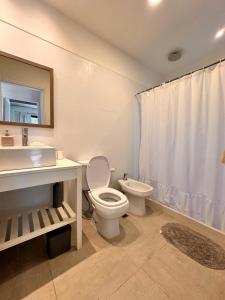 a bathroom with a toilet and a sink at Casa Amapola in José Ignacio