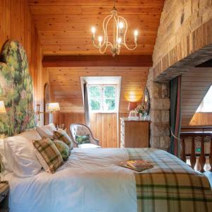 a bedroom with a large bed in a wooden room at The Shooting Lodge in Charminster