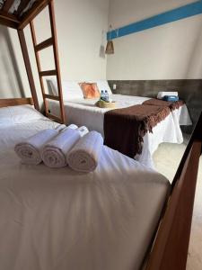 two beds in a room with towels on them at Pousada Villa Santorini Preá in Cruz +3 photos